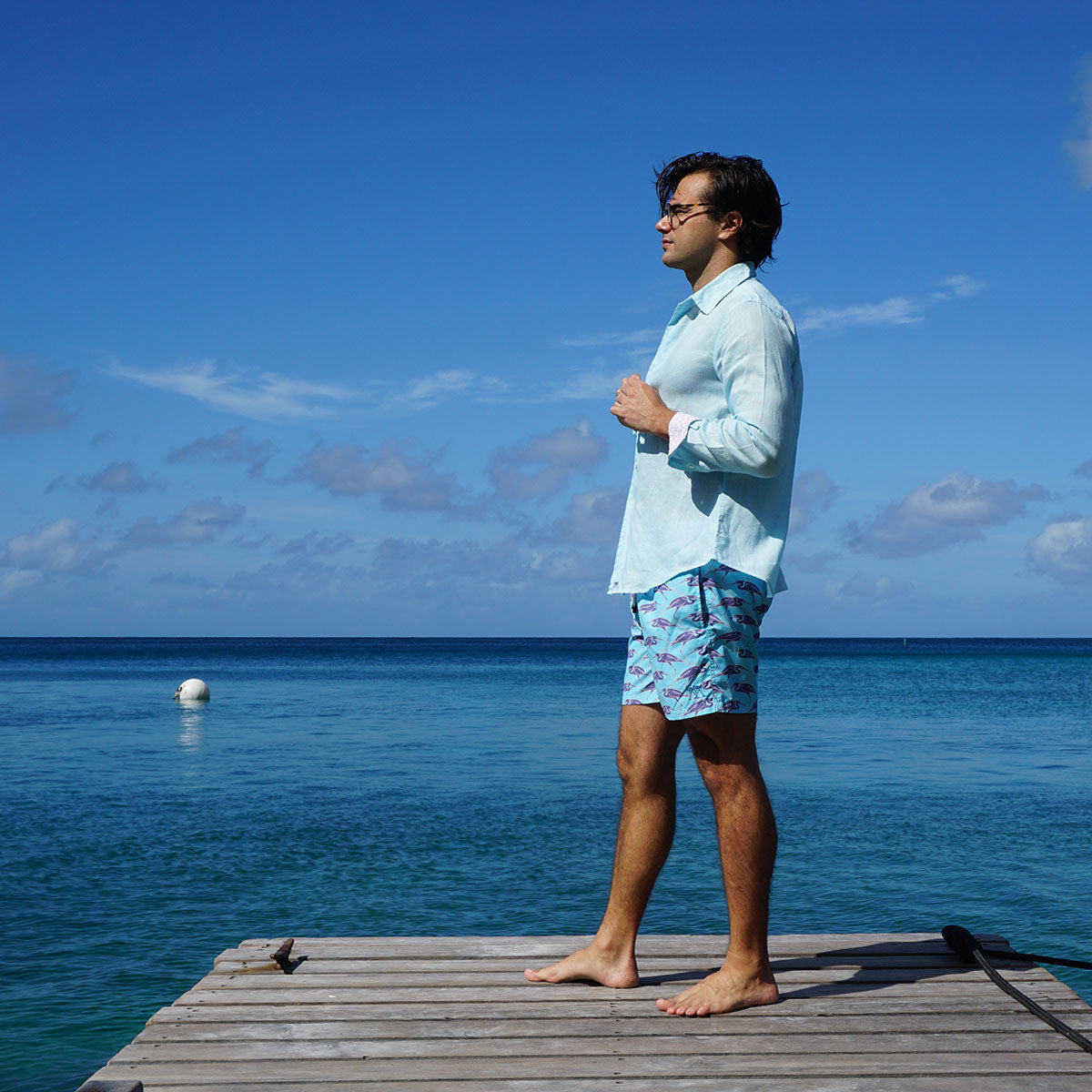 Sustainable Mens tropical holiday shorts in blue Egret bird print Cotton House pier, Mustique