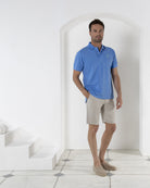 Designer men's style casual linen shorts in natural beige worn with mid blue polo by Pink House