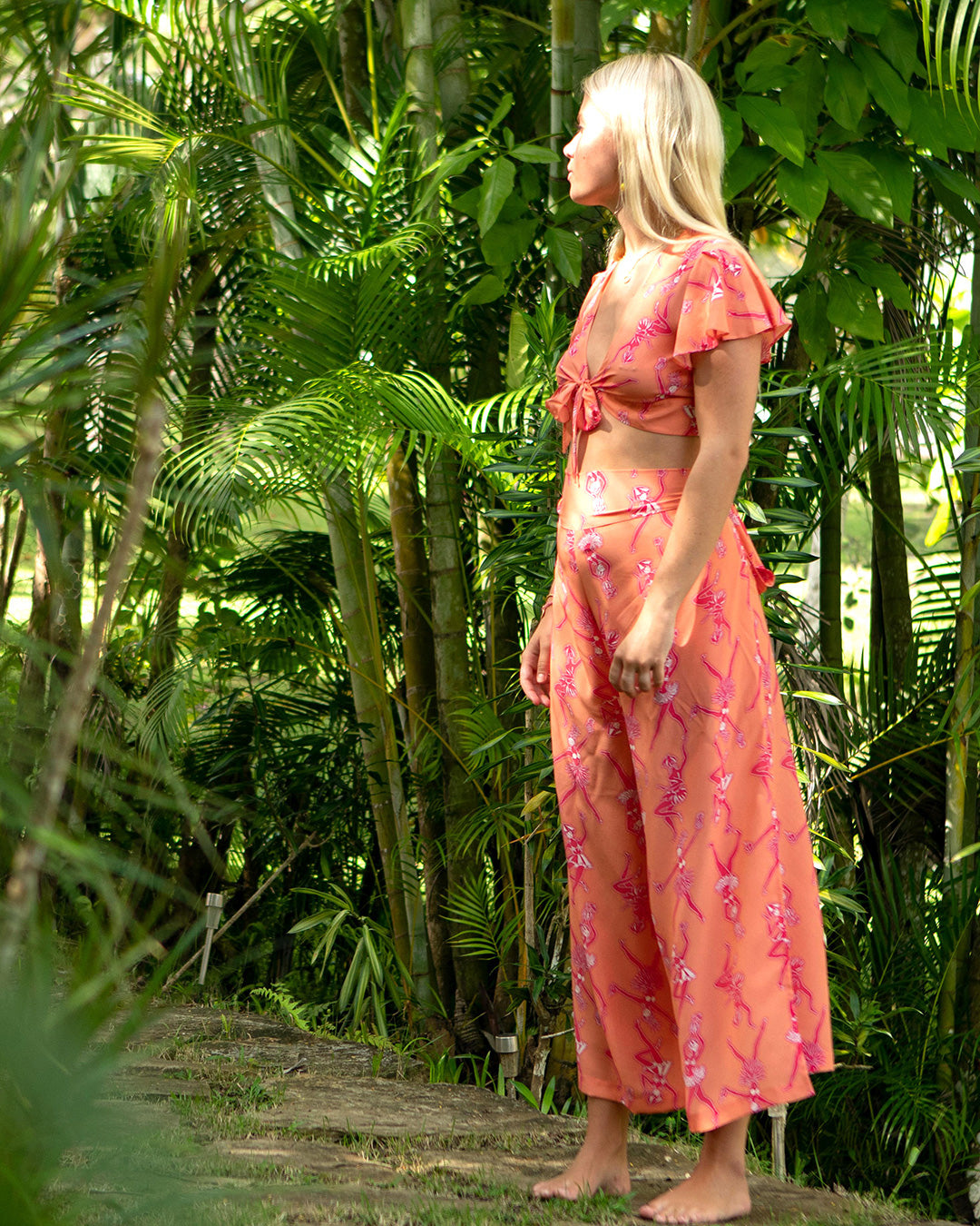 Tropical holiday style silk Lyla crop top in Fruit Punch pink and orange print worn with matching palazzo pants by designer Lotty B for Pink House