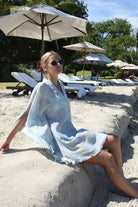 Lotty B Short Kaftan in Silk Crepe-de-Chine: PINEAPPLE - OLIVE sitting under an umbrella Mustique