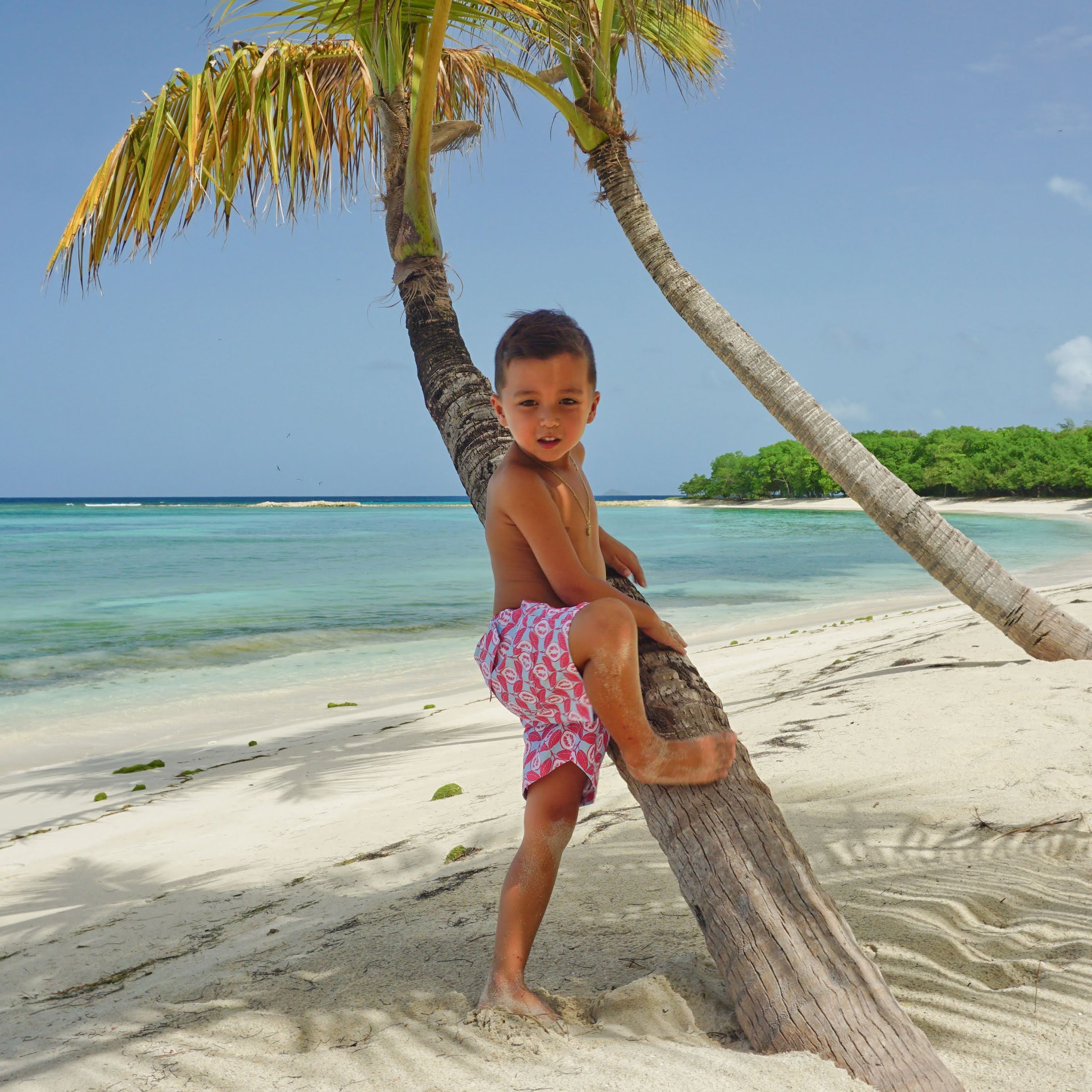 Boys swim shorts in Guava red print by designer Lotty B Mustique summer style