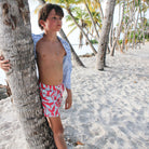 Boys fun beach swim trunks in turquoise blue and coral red Striped Shell print by designer Lotty B